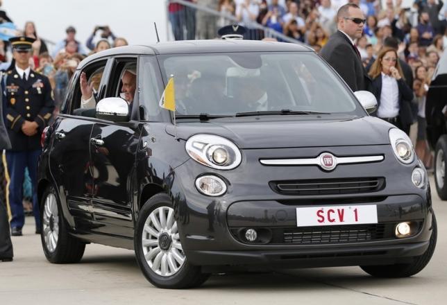 Pope Francis waves as he is driven away in a Fiat 500 model after arriving in the United States at Joint Base Andrews outside Washington in this September 22, 2015 file photo. REUTERS/Jonathan Ernst/Files